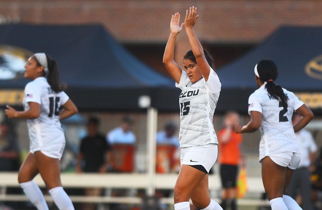 Julissa Cisneros claps three times above her head after scoring a goal